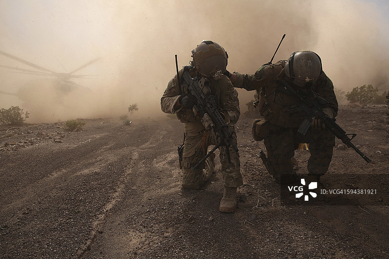 士兵们准备迎接降落在CH-53超级种马上的沙砾和石块的冲击。图片素材