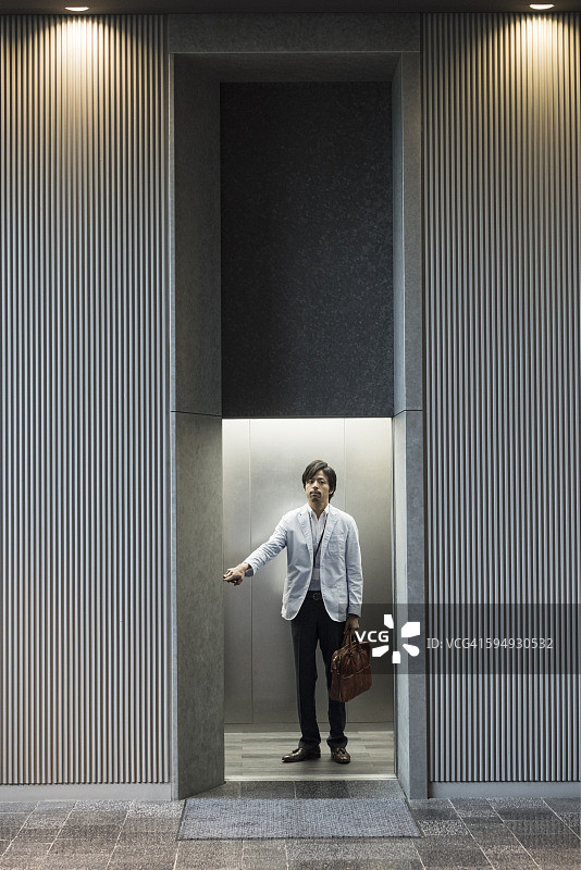 日本商人在现代办公电梯图片素材