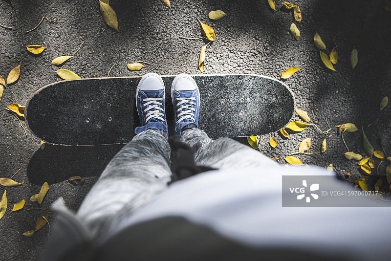 男孩站在滑板上的路径与秋叶图片素材