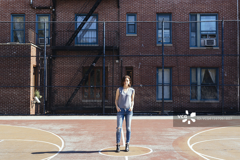 美国，纽约市，曼哈顿，一个年轻女子站在操场上图片素材