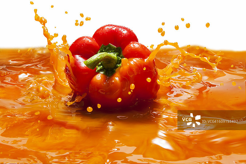 橙甜椒落在蔬菜汁里图片素材