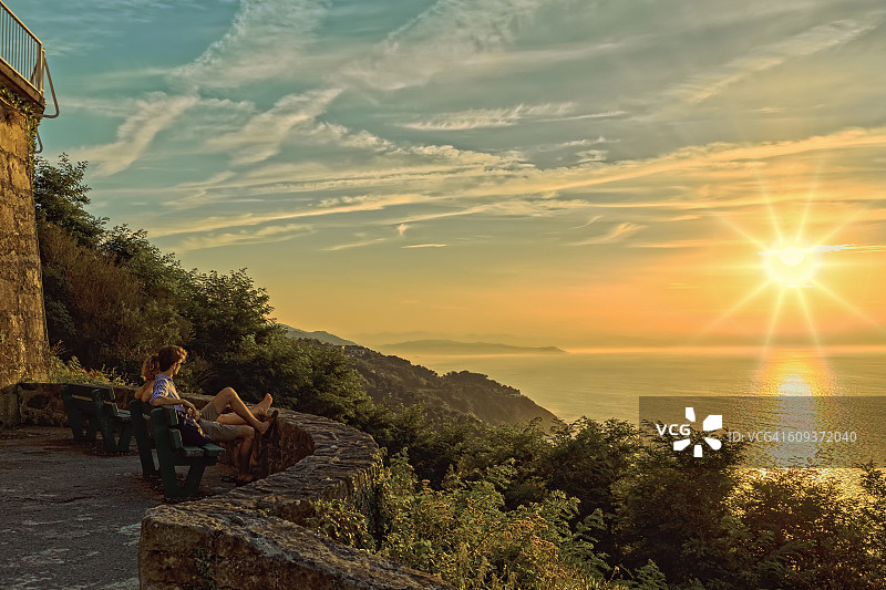 一对夫妇在西班牙的伊格尔多山眺望日落和大海图片素材