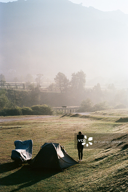 站在帐篷和摩托车旁边的女人图片素材