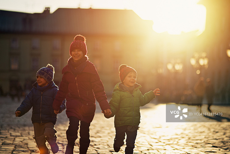 三个孩子在秋天参观克拉科夫老城图片素材