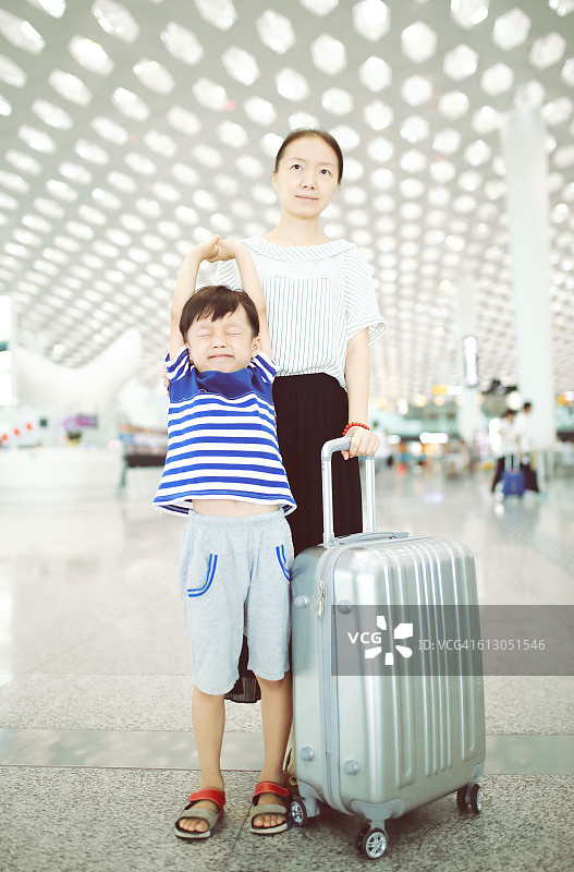 一个女人带着她的孩子经过机场航站楼图片素材