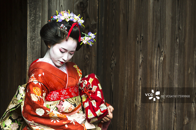 穿着和服的艺妓在传统的日本巷子里等待图片素材