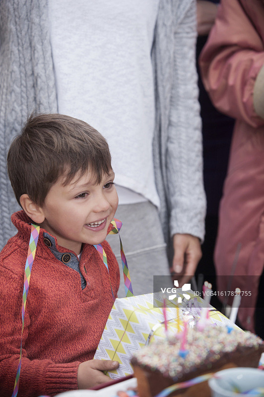 德国巴伐利亚，小男孩在生日派对上拿着礼物微笑图片素材