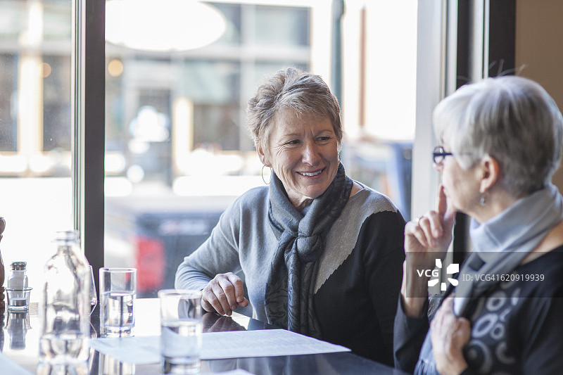 两个年长妇女在一家餐厅讨论图片素材