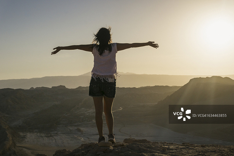 智利，阿塔卡马的圣佩德罗，一个在阿塔卡马沙漠里张开双臂的女人图片素材