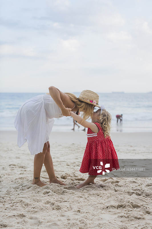 巴西，里约热内卢，母亲在科帕卡巴纳海滩亲吻女儿图片素材