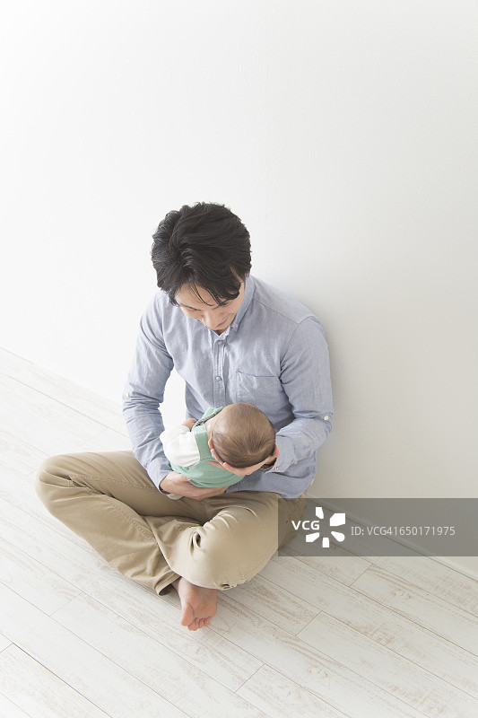 日本男人用摇篮抱着婴儿图片素材
