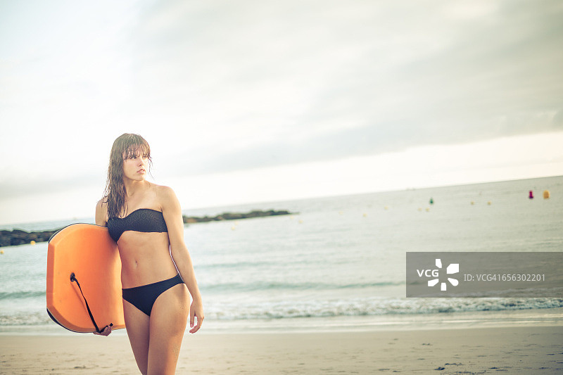 西班牙，特内里费岛，在海滩上玩冲浪板的年轻女子图片素材