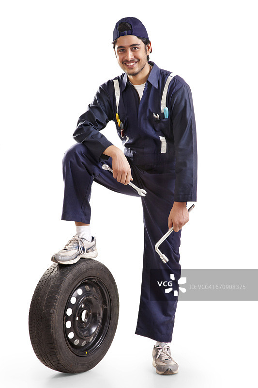 汽车技师的肖像与备用轮胎和手工具图片素材
