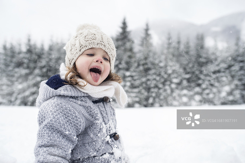 冬日风景里的女孩用她的舌头捕捉雪花图片素材