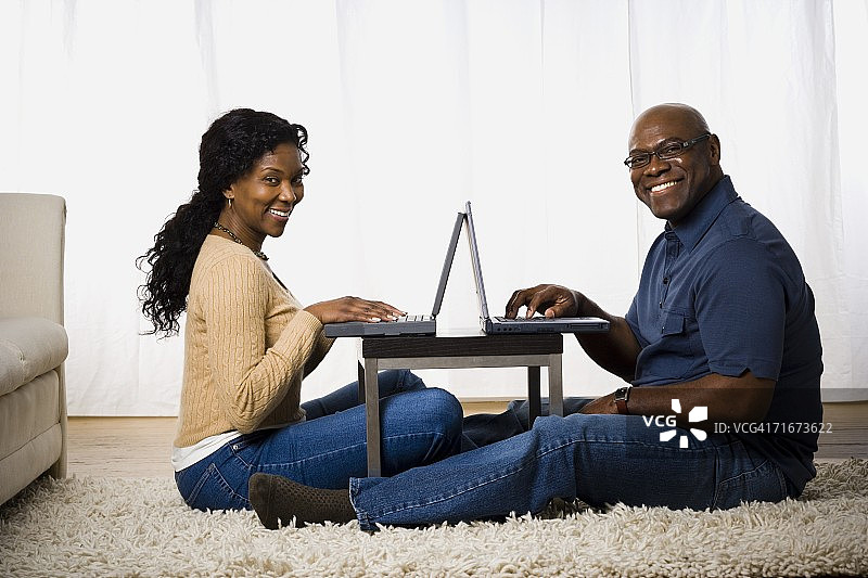一对成熟的夫妇使用笔记本电脑图片素材