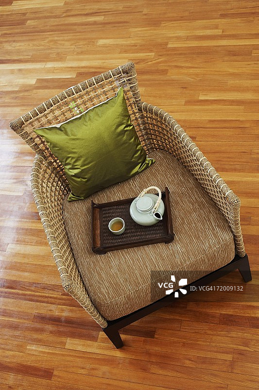 高角度的茶壶和茶杯与托盘在扶手椅图片素材