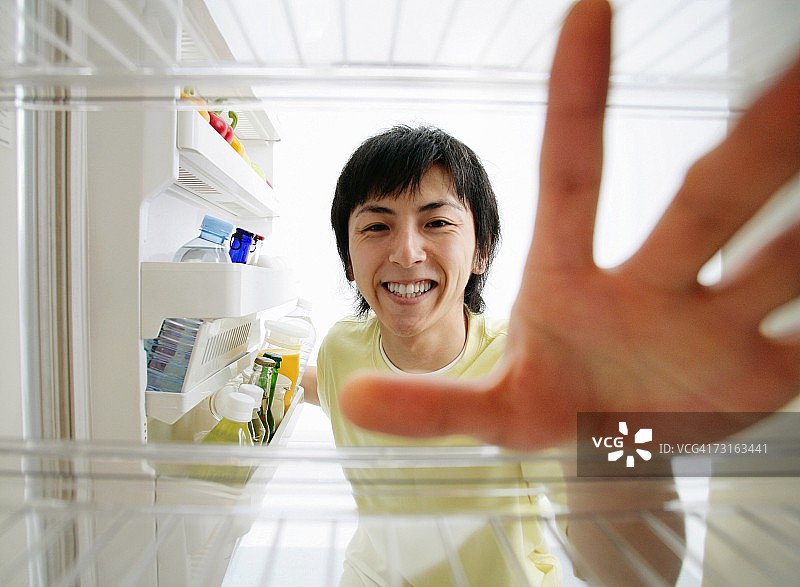 一个男人在冰箱里找东西图片素材