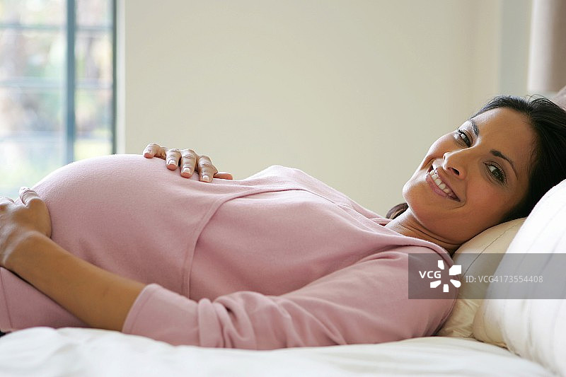 一个印度孕妇躺在床上的肖像图片素材