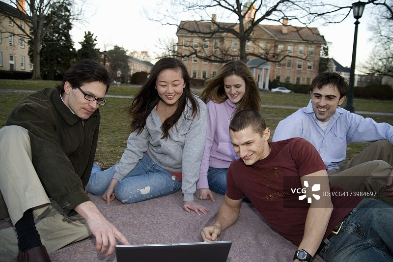 大学生与讲师坐在草地上图片素材