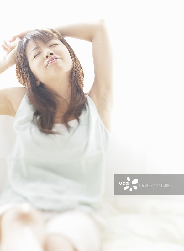 日本妇女伸展和闭上眼睛图片素材