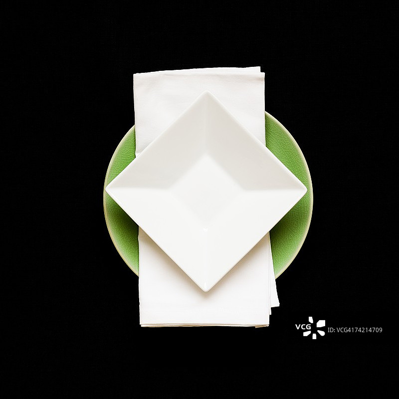 餐巾上的方形盘子，下面是圆形盘子图片素材