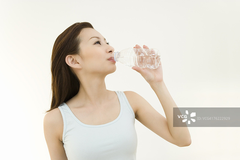 一个喝水的女人，正面，白色背景图片素材