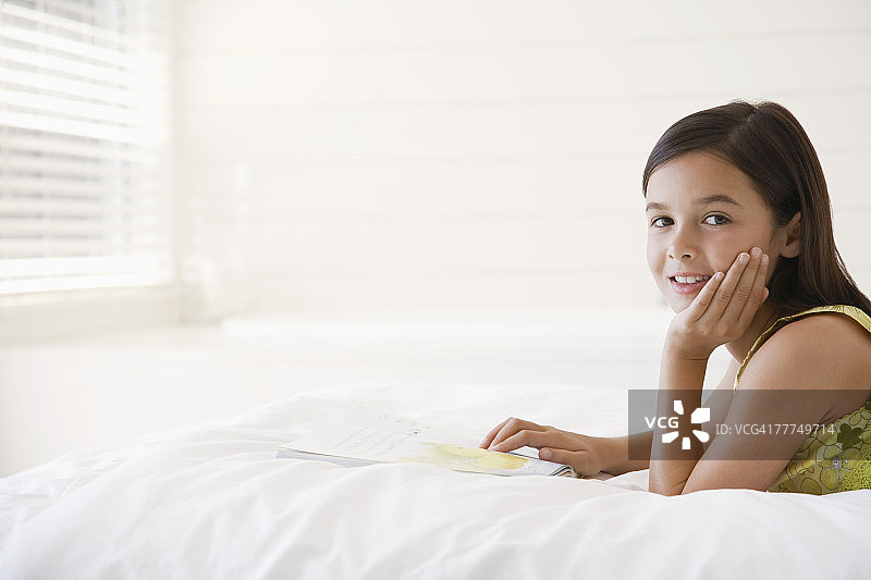 小女孩在床上看书图片素材