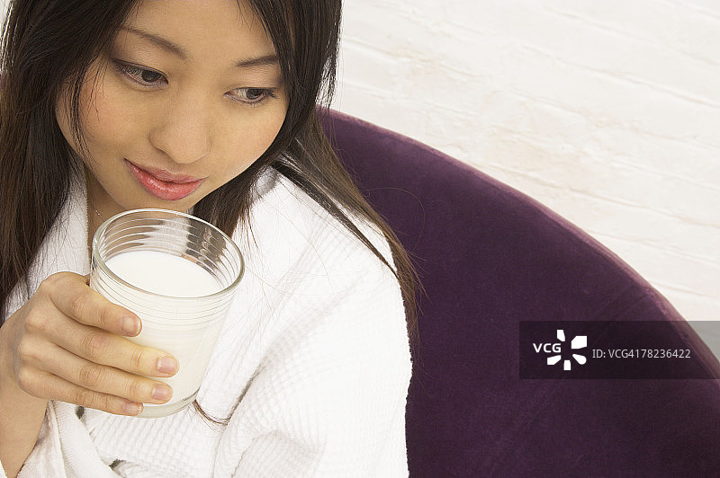 年轻的日本妇女喝牛奶的肖像图片素材