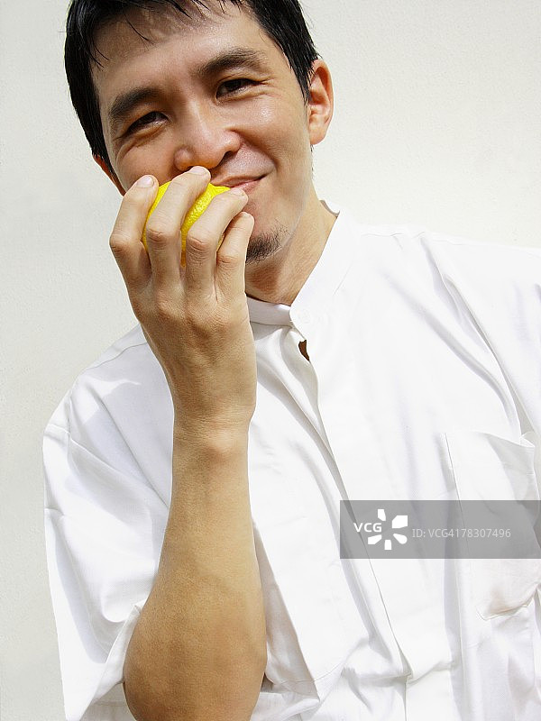 一个中年男人的肖像，拿着一个柠檬，笑着图片素材