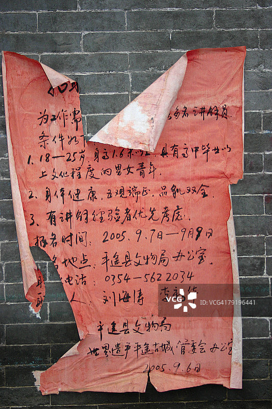 中国陕西省平遥，一张撕破的墙上海报的特写图片素材