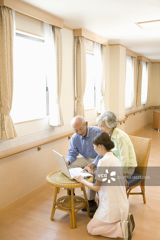 年长的男男女女和护士在看笔记本电脑图片素材