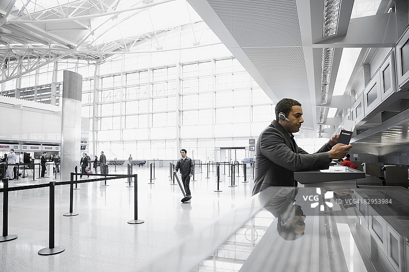 一个商人站在机场售票处的侧影图片素材