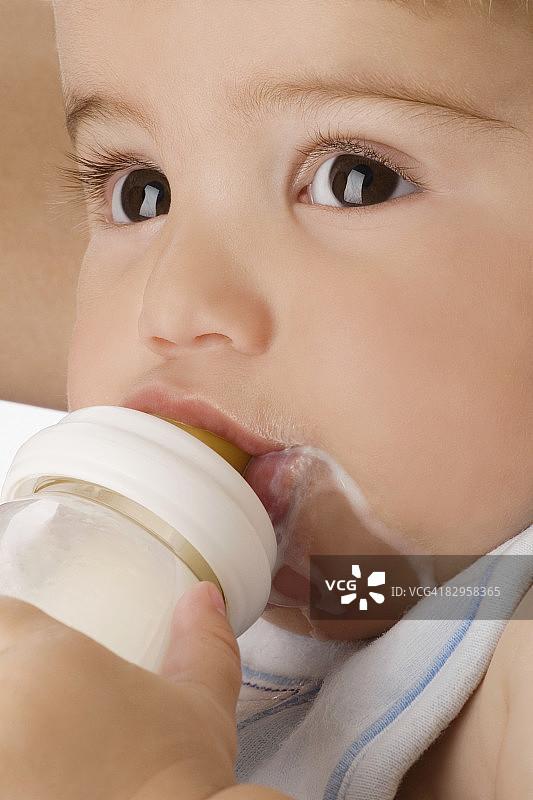 一个男婴从奶瓶里喝牛奶的特写图片素材
