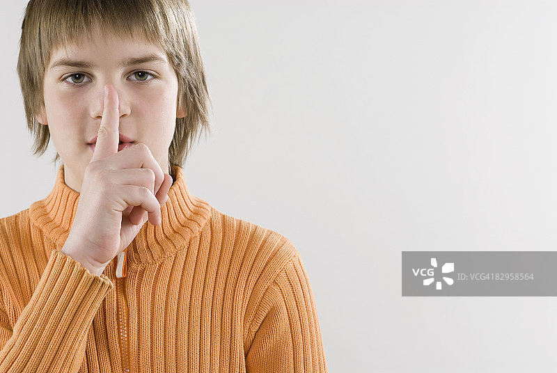 一个男孩做了一个沉默的手势图片素材