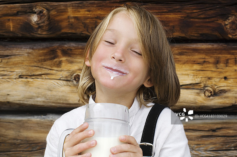 奥地利，萨尔茨堡国，男孩(8-9)捧着一杯牛奶，闭着眼睛，特写图片素材