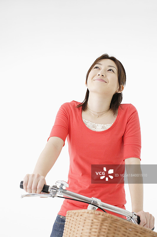骑着自行车的女人，向上看，照相馆拍摄图片素材
