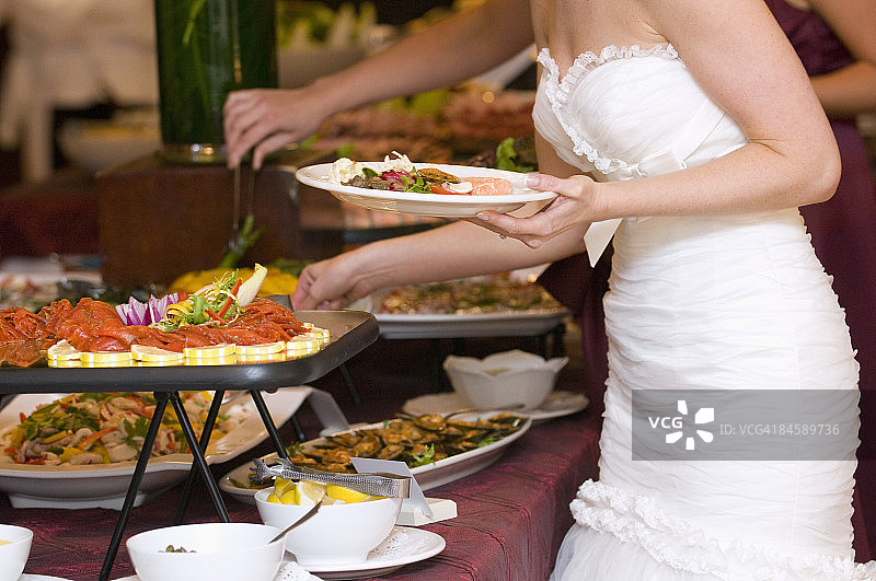 新娘从自助餐厅领取食物。图片素材