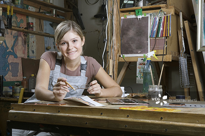 一个在画室工作的年轻女人，肖像画图片素材