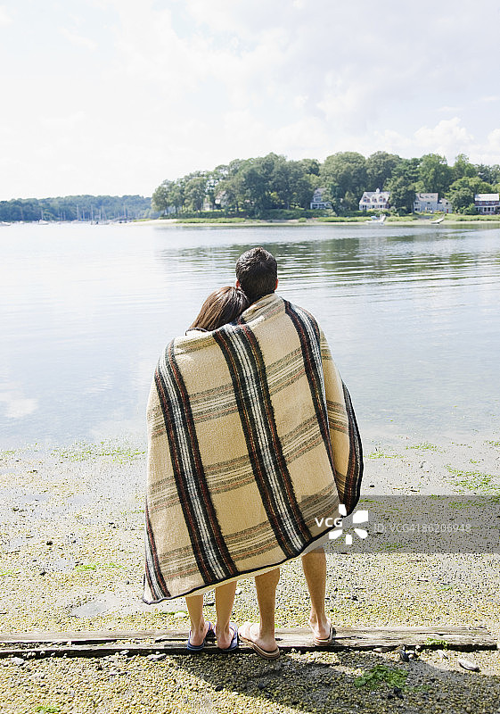 一对夫妇裹着毯子望着湖面图片素材