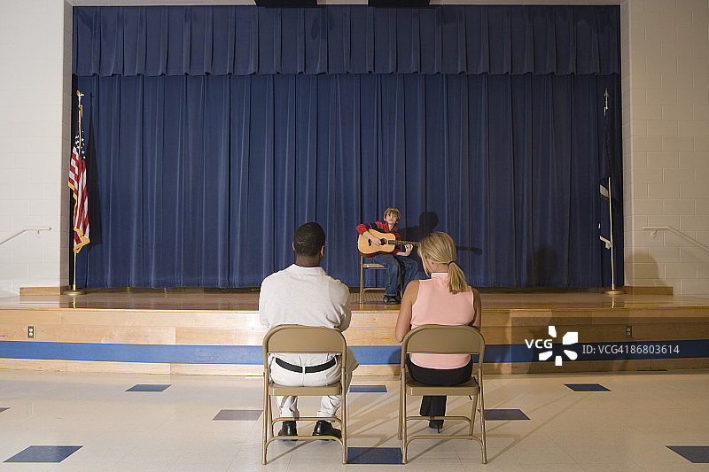 老师在台上看着学生弹吉他图片素材