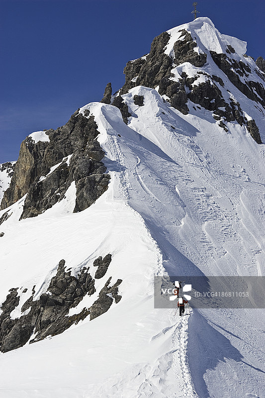 在奥地利阿尔伯格的圣安东，两名男子带着滑雪板徒步登山，在没有足迹的雪道外滑雪。图片素材