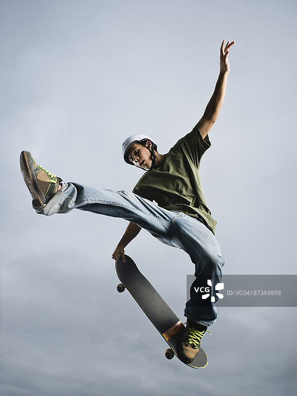 混血少年在半空中玩滑板图片素材