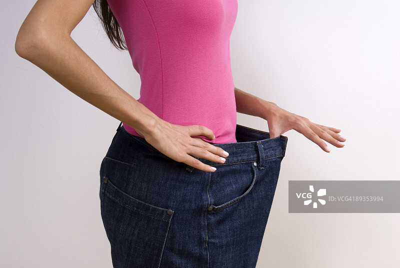 女人穿着大号牛仔裤，节食图片素材