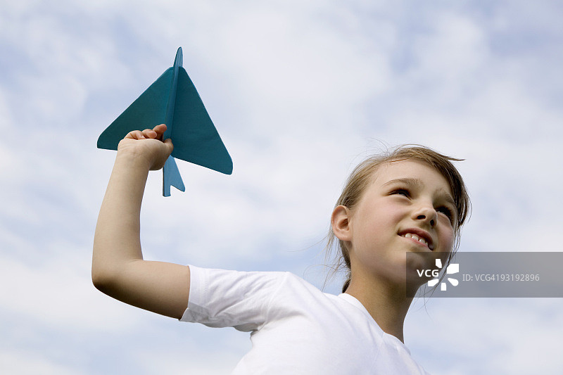 一个小女孩拿着一个模型飞机图片素材