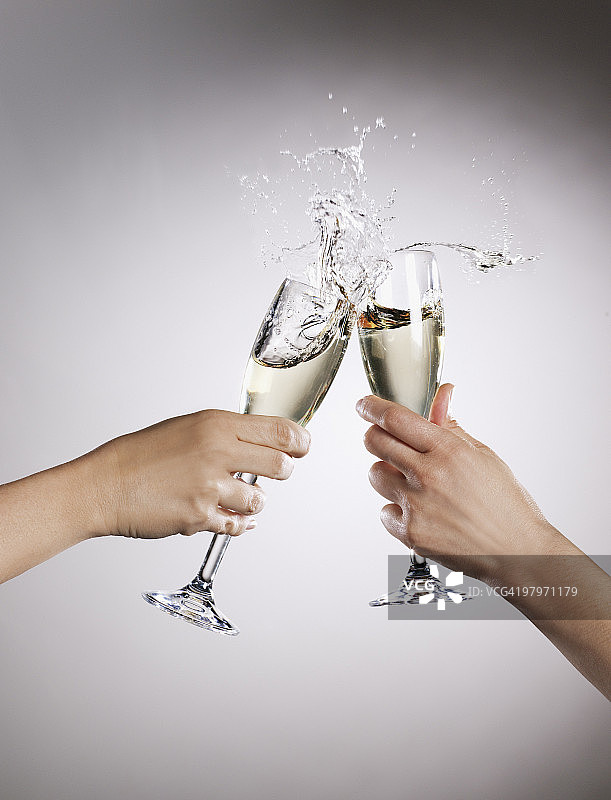 一对夫妇举杯互敬，香槟洒了出来图片素材