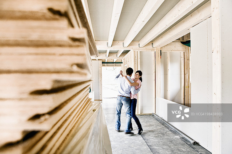 一对年轻的夫妇在他们新家的建筑工地跳舞图片素材