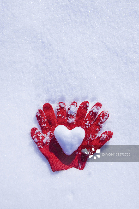 红色的手套和雪做的心图片素材