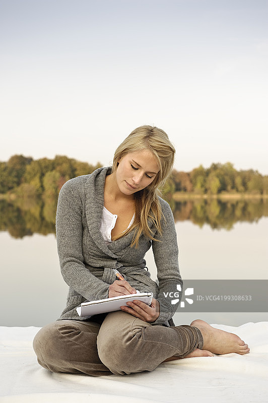 年轻女子在湖边写生图片素材