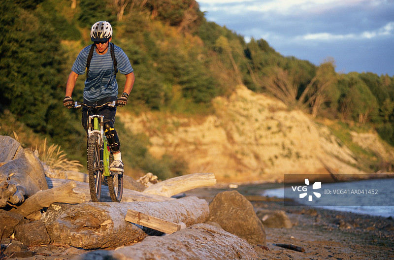 沿着海滩骑自行车的男人图片素材