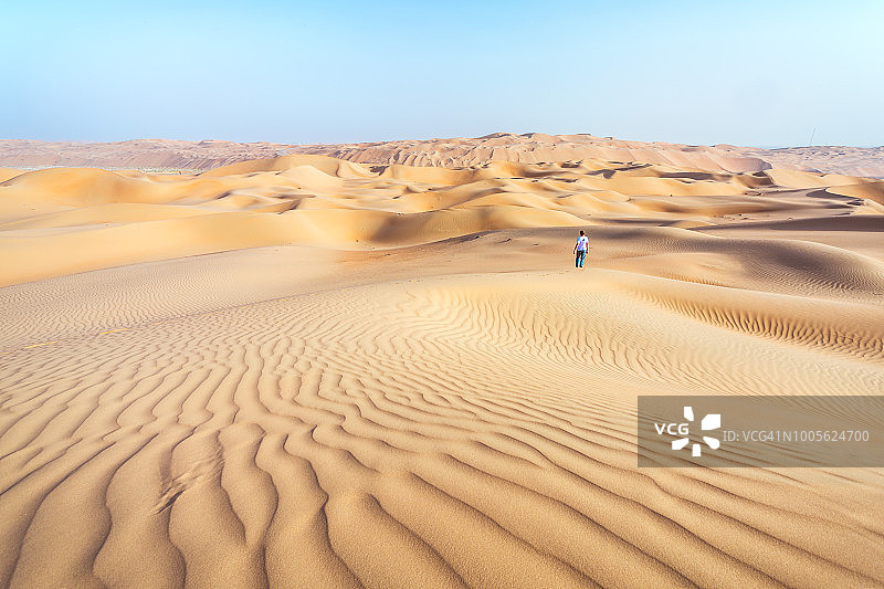 阿布扎比沙漠沙丘上的孤独男子图片素材